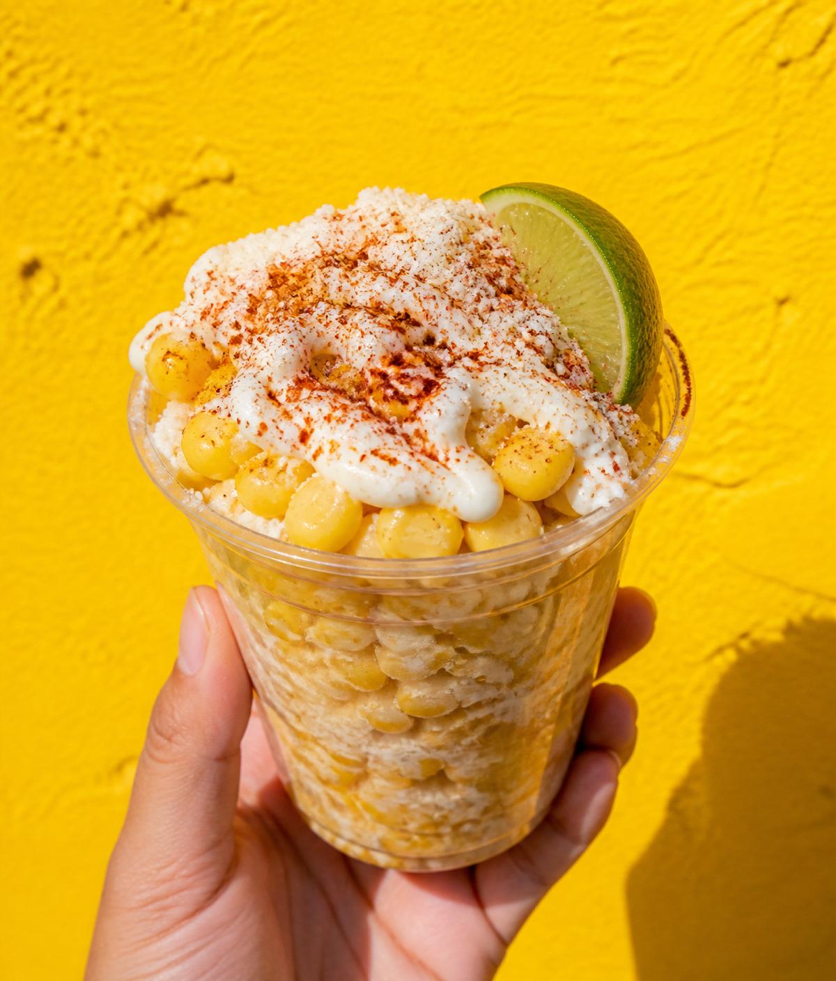 Elote en vaso topped with cotija and chile